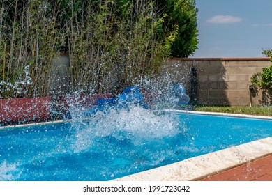 A Huge Splash Of Water Is Created By The Cannonball Dive Into A Swimming Pool