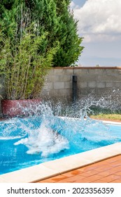 A Huge Splash Of Water Is Created By A Cannonball Dive Into A Swimming Pool