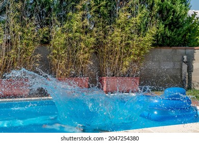 A Huge Splash Of Water Is Created By A Cannonball Dive Into A Swimming Pool