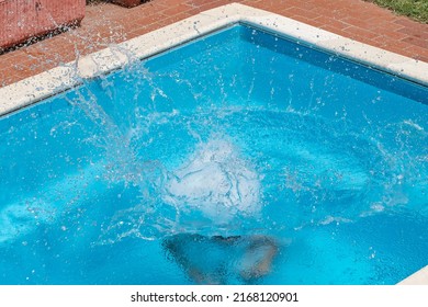 A Huge Splash Of Water Is Created By A Cannonball Dive Into A Swimming Pool