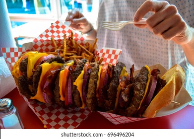 A Huge Stacked Burger And Fries