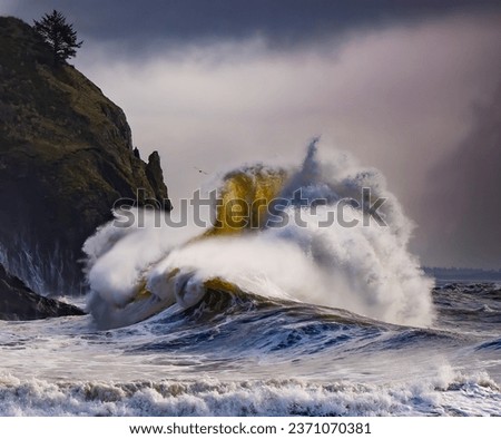 Huge wave crashing on headland under Cape Disappointment lighthouse near mouth of Columbia River, Ilwaco, WA,  center of wave is sharp, exterior of wave is blurred to emphasize motion