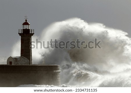 Huge wave over old lighthouse of Porto, Portugal. Low edition photo.