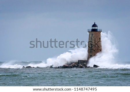 Huge waves crash around Whaleback lighthouse after storm tidal surge in Maine. Waves created by astronomically high tides after storm passes.