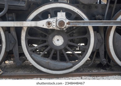 Huge wheel of an old steam locomotive on the rails
