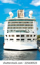Huge white passenger cruise ship in port on a blue sky background. Outdoors