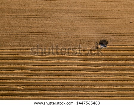 Similar – Image, Stock Photo Combine harvester harvests a grain field in the evening light from the air