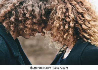 hugging adult son and mom with curly hair 
