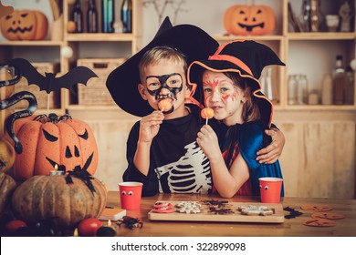 Hugging Boy And Girl Enjoying Sweets At Halloween Party