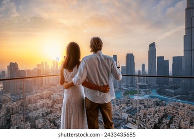 A hugging couple enjoys the beautiful sunset behind the skyline of Downtown Dubai, UAE - Powered by Shutterstock