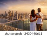 A hugging couple enjoys the panoramic sunset view of the Dubai Marina, UAE
