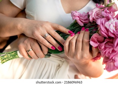 hugging hands of newlyweds with rings and flowers close-up - Shutterstock ID 2186096963