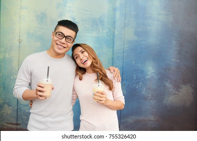 Hugging Happy Young Vietnamese Couple Drinking Milkshakes