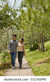 Hugging Young Asian Couple Walking In Park