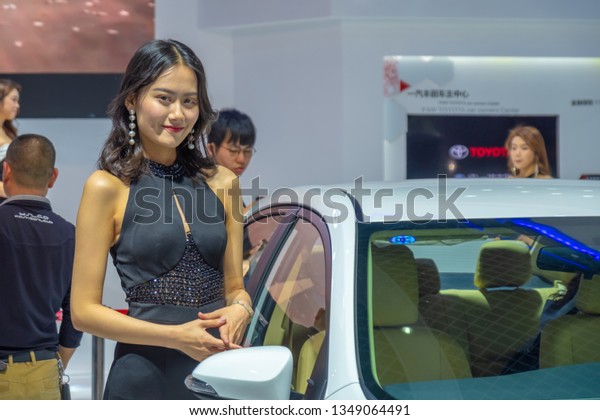 Huizhou, China - MAR 2019: Unidentified female\
model posed for photograph with the new car by Toyota at the\
Huizhou Broadcasting Auto Show in\
spring