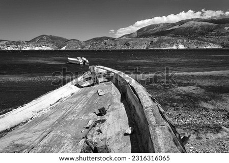 The hull of an old, damaged, boat on the seashore on the island of Kefalonia in Greece, monochrome