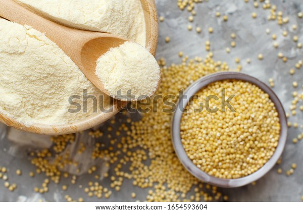 Hulled millet flour and grain top view on a\
gray background