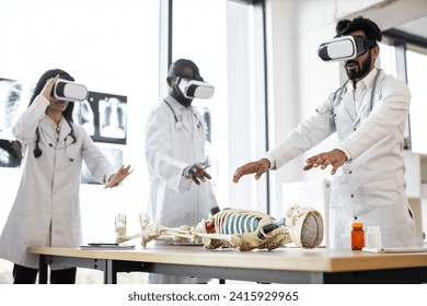 Human anatomy, VR, education, medicine concept. Young multiracial researchers using virtual reality goggles while working with human skeleton. Team of scientists in modern laboratory - Powered by Shutterstock