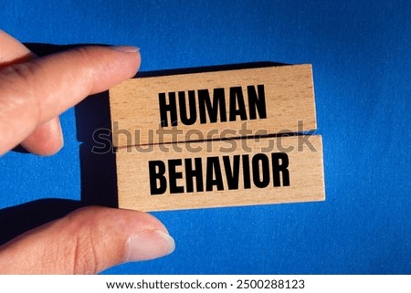 Human behavior message written on wooden blocks on blue background. Conceptual human behavior symbol. Copy space.
