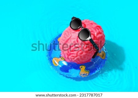 Human brain character, adorned with stylish sunglasses, indulges in a relaxing sunbathing session as it floats gracefully in a pool ring. Mental rejuvenation, leisure and self-care concept.