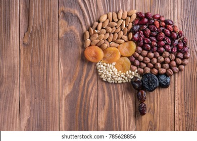 Human brain is made of dried apricots and nuts on a wooden table.   Concept of healthy food. 