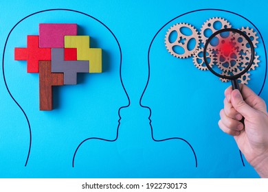 Human brain is made gear mechanism and colourful shapes on blue background. The brain is viewed through a magnifying glass. Brain disturbance concept, brain disorder. Different thinking.