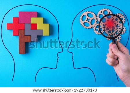 Human brain is made gear mechanism and colourful shapes on blue background. The brain is viewed through a magnifying glass. Brain disturbance concept, brain disorder. Different thinking.