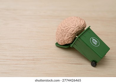 Human Brain Model Inside Small Green Garbage Bin Representing Mental Waste or Burnout
