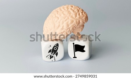 Human brain model with rocket and flag symbols representing ambition achievement goal success innovation motivation and strategic thinking concept. 