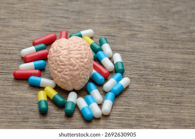 A human brain model surrounded by colorful pills, symbolizing the treatment of neurological and mental health disorders through modern pharmacology.