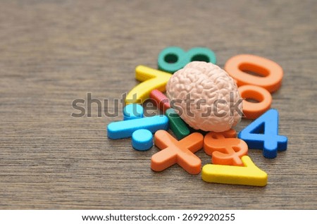 A human brain model surrounded by colorful numbers and symbols, representing cognitive function, calculation, and logical reasoning.