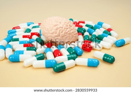 Human brain model surrounded by colorful capsules, representing brain medication, neurological treatment, mental health, neuroscience, pharmacy and healthcare.