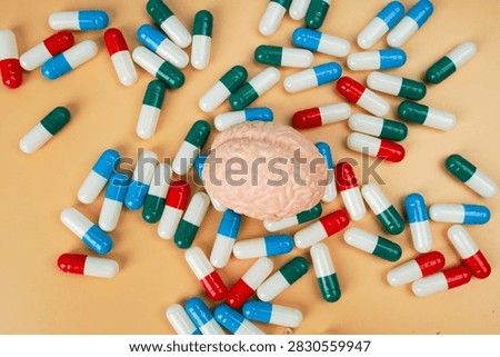 Human brain model surrounded by colorful capsules, representing brain medication, neurological treatment, mental health, neuroscience, pharmacy and healthcare.