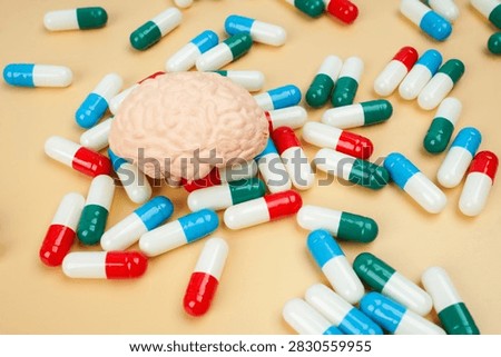 Human brain model surrounded by colorful capsules, representing brain medication, neurological treatment, mental health, neuroscience, pharmacy and healthcare.