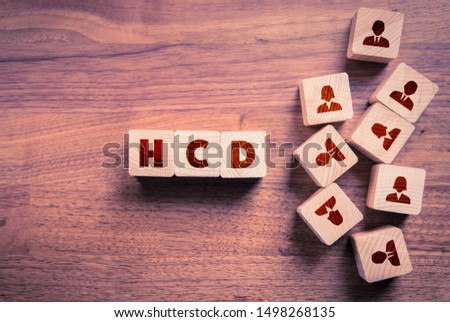 Human Centered Design (HCD) concept. Wooden cubes with text HCD and cubes with people icons representing word human.
