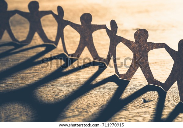 Human\
chain paper with light and shadow on wood\
table