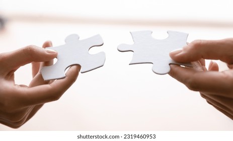Human connecting two pieces of puzzle. Woman joining jigsaw parts. Business person offering great solution for client needs, finding best problem solving. Perfect match in partnership concept