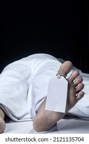 Human Corpse Covered With A Sheet And Name Tag On Toe In The Morgue