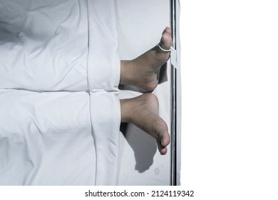 Human corpse covered with a sheet and name tag on the toe with white background - Shutterstock ID 2124119342