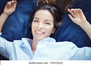 Human emotions, expressions and feelings. Close up shot of gorgeous mixed race female student smiling at camera showing white straight teeth, having carefree look. Blue eyed lady having rest at home.