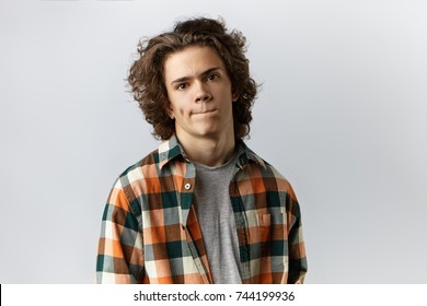 Human Emotions, Feelings, Reaction And Attitude. Isolated Picture Of Stylish Unsure Young Male Wearing Trendy Checkered Shirt Pursing Lips, Feeling Nervous Before First Date With Gorgeous Woman