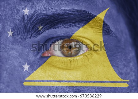 Human face and eye painted with flag of Tokelau