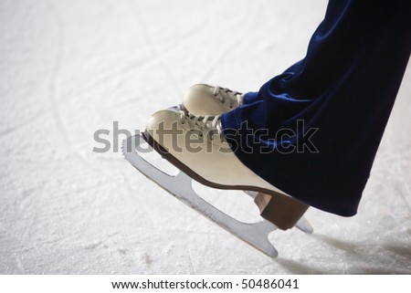 Human feet in fads standing on ice on the brink of an edge on skating rink