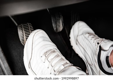 Human feet pressing car pedal. - Shutterstock ID 1992998897