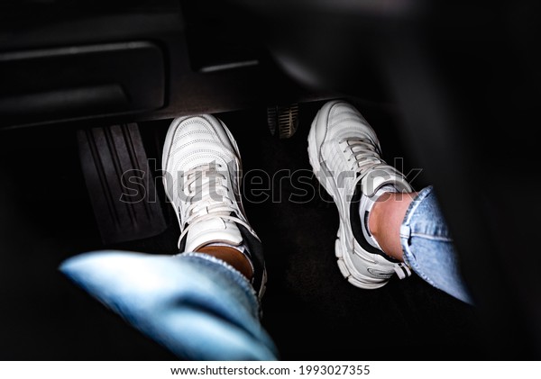 Human feet pressing car\
pedal.