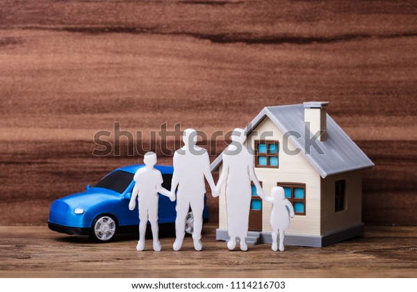 Human Figures Standing In Front Of House And Blue\
Car On Wooden Plank