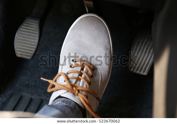 Human foot pressing car\
pedal
