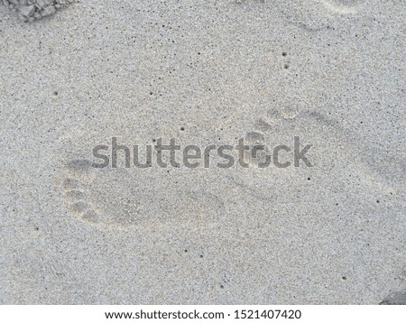 Human footprints on the sand at the beach.