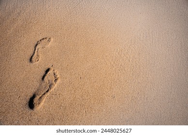 Human footprints in the sand on the sea beach - Powered by Shutterstock