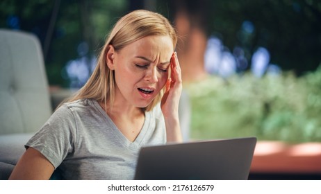 Human Going Through Headache: Close Up of a Female Working on Laptop Computer and Experiencing Discomfort and Migraine. Sudden Serious Pain Is Preventing Woman From Working on Laptop Computer.